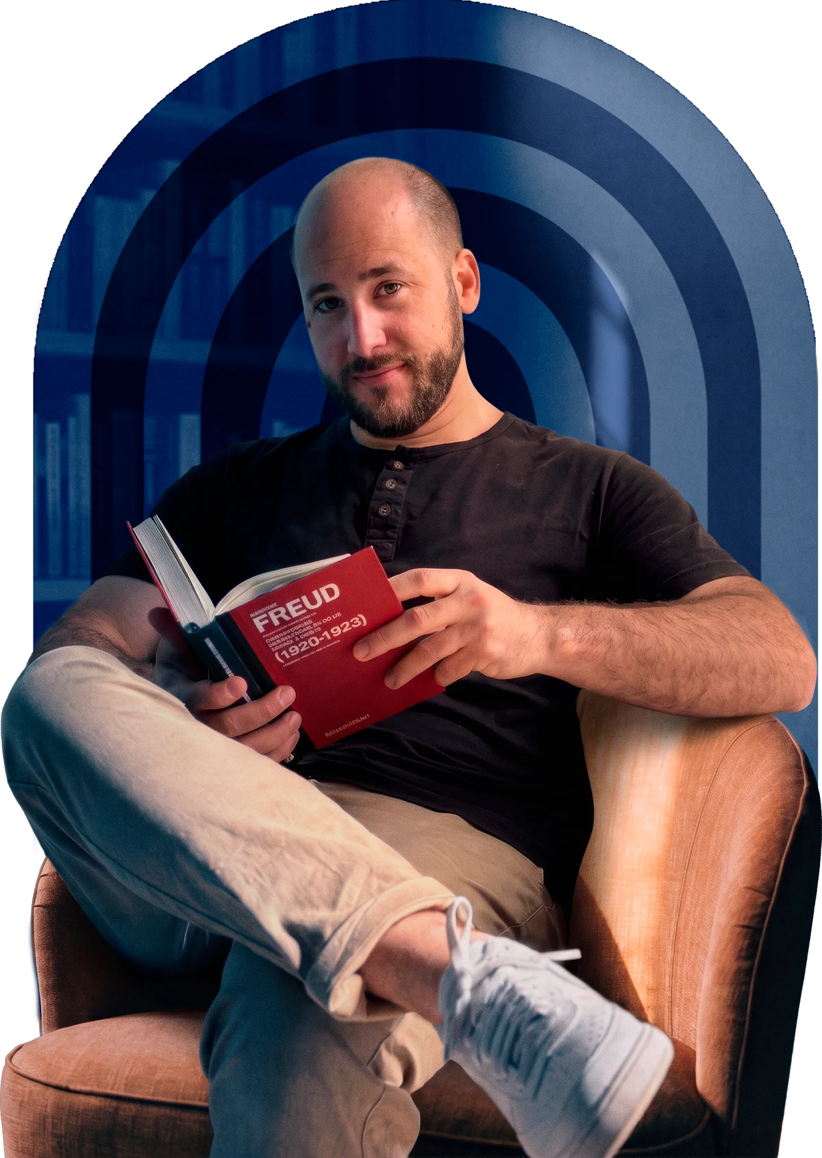 Natanael Jotar sentado em uma poltrona, segurando um livro